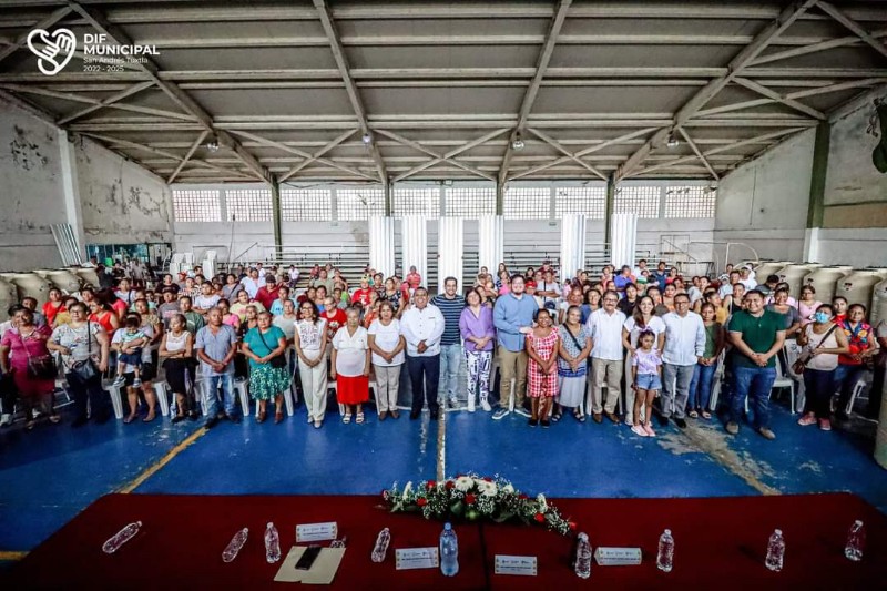 Entrega de paquetes de láminas y tinacos contenedores de agua.